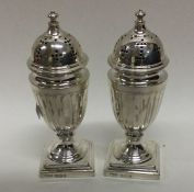 A pair of Victorian fluted silver peppers on squar