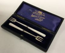 A cased pair of silver and ivory pickle forks. Bir