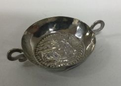 A chased silver dish decorated with animals and fi