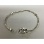A modern silver bracelet with heart shaped clasp.