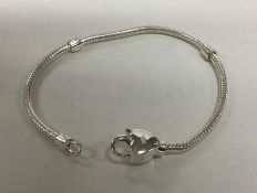 A modern silver bracelet with heart shaped clasp.