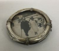 A circular silver picture frame in the form of a l