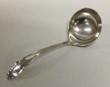 An Edwardian silver sauce ladle with shaped handle