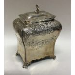 A shaped Georgian silver tea caddy on scroll feet