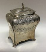 A shaped Georgian silver tea caddy on scroll feet