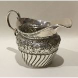 An embossed silver bachelor's cream jug of half fl