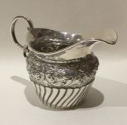 An embossed silver bachelor's cream jug of half fl