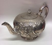 A good quality embossed silver teapot decorated wi