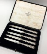 A set of five silver plated knives contained withi