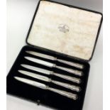 A set of five silver plated knives contained withi