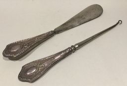 A pair of silver mounted button hooks / shoe horns