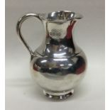 A novelty silver cream jug in the form of a milk c