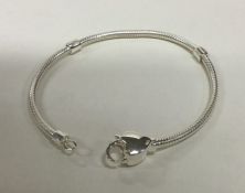 A modern silver bracelet with heart shaped clasp.