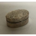 A small oval engraved silver pill box. Approx. 8 g