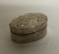 A small oval engraved silver pill box. Approx. 8 g