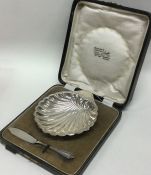 A cased silver butter shell together with matching