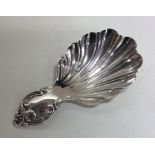 A Victorian fluted silver caddy spoon with scroll