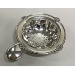 An attractive silver tea strainer with plain thumb