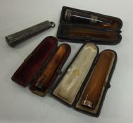 A group of three silver mounted and amber cheroot