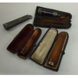 A group of three silver mounted and amber cheroot
