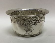 A chased silver sugar bowl decorated with flowers