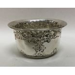 A chased silver sugar bowl decorated with flowers