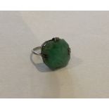A carved jade single stone ring in claw mount. App
