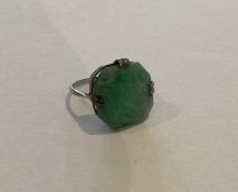 A carved jade single stone ring in claw mount. App