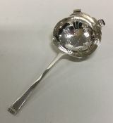 A stylish silver tea strainer with pierced bowl. S