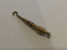 A small gold mounted miniature button hook. Approx