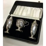 A heavy silver cased three piece silver cruet set.