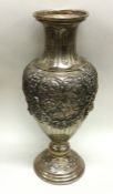 A massive chased silver vase profusely embossed wi