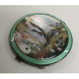 A circular silver and enamelled compact decorated