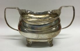 A Georgian crested silver sugar bowl on four flute