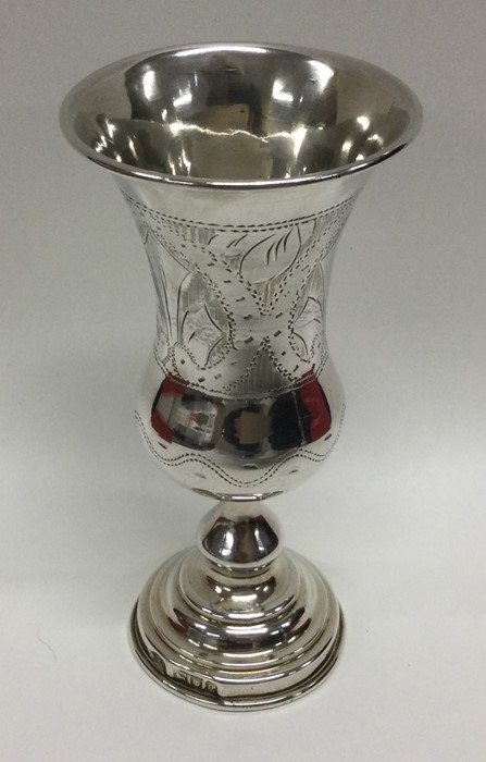 A tapering silver vase decorated with flowers. Lon