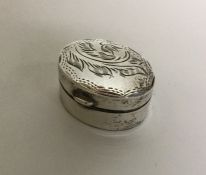 An oval engraved silver pill box with hinged lid.