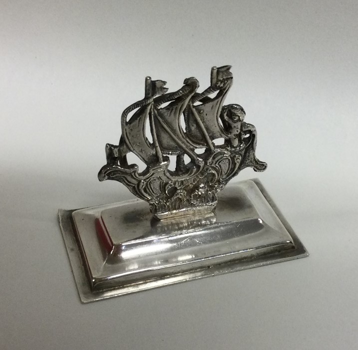 A cast silver menu holder in the form of a Galleon