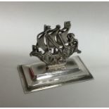 A cast silver menu holder in the form of a Galleon