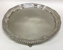 A circular silver salver with gadroon rim. London