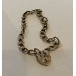 A 9 carat curb link bracelet with heart shaped pad