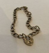 A 9 carat curb link bracelet with heart shaped pad