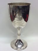 A large engraved silver goblet on sweeping pedesta