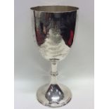 A large engraved silver goblet on sweeping pedesta