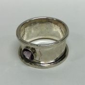 An Arts & Crafts silver napkin ring mounted with a