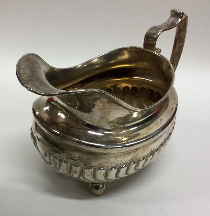 A Georgian silver half fluted cream jug on ball fe