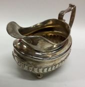 A Georgian silver half fluted cream jug on ball fe