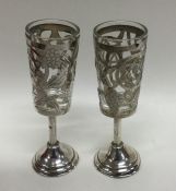 A pair of silver and overlaid shot glasses. Approx