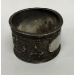 A Chinese silver napkin ring decorated with figure