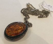 A silver and amber pendant on fine link chain. App