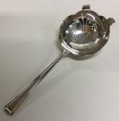 A stylish silver tea strainer with pierced bowl. S